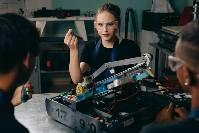 Engineering students building a robot in a workshop